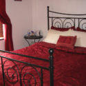 Traditional red and cream colored bedding on an IKEA NORESUND bed