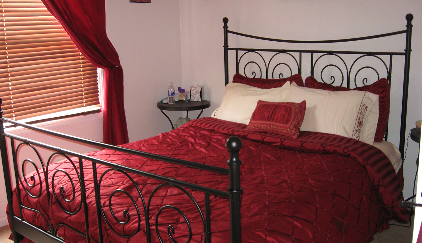 Traditional red and cream colored bedding on an IKEA NORESUND bed