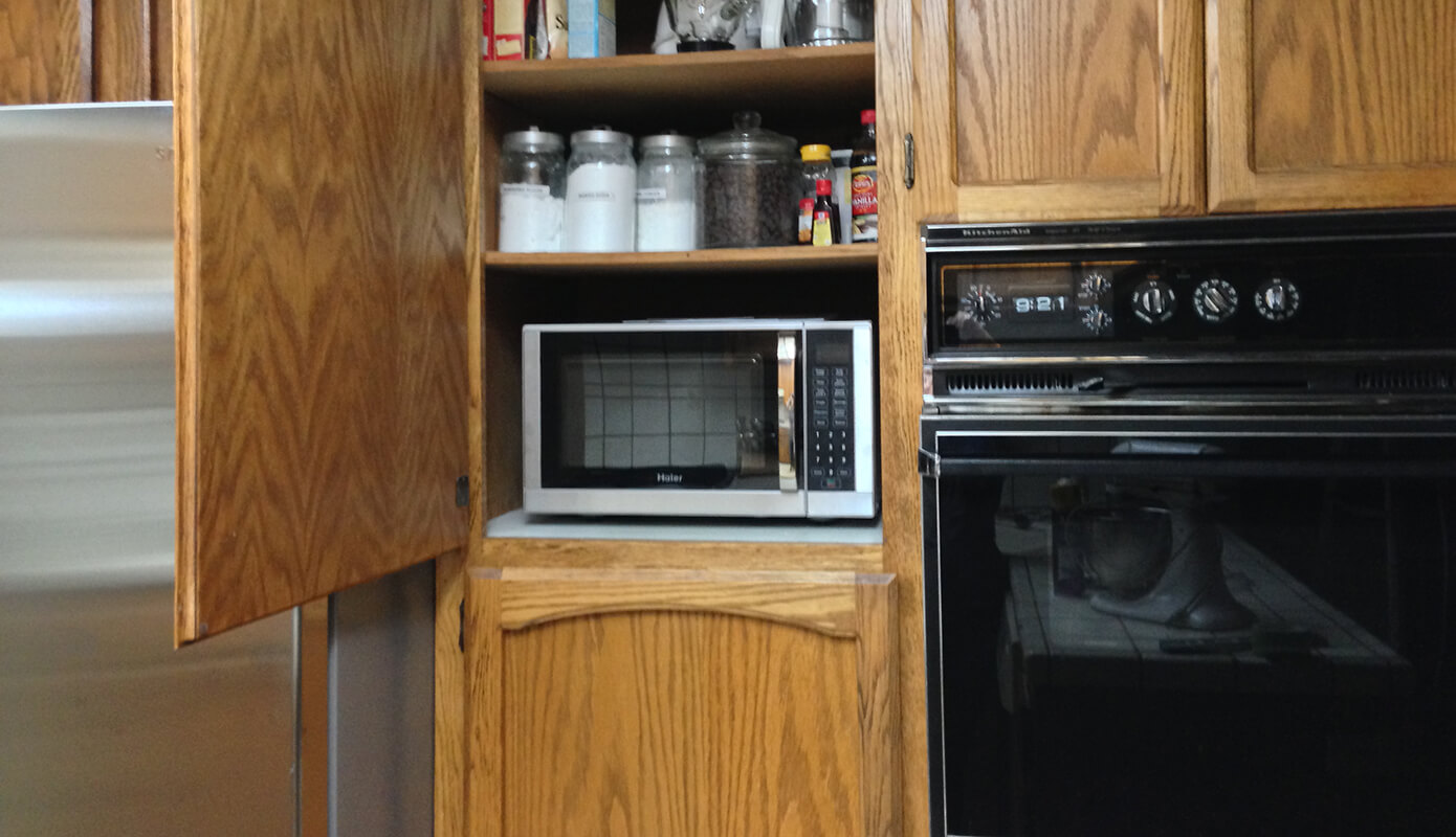 Made a spot for the microwave by cutting a small hole in the cabinet and using the outlet behind the fridge. #thelovelygeek