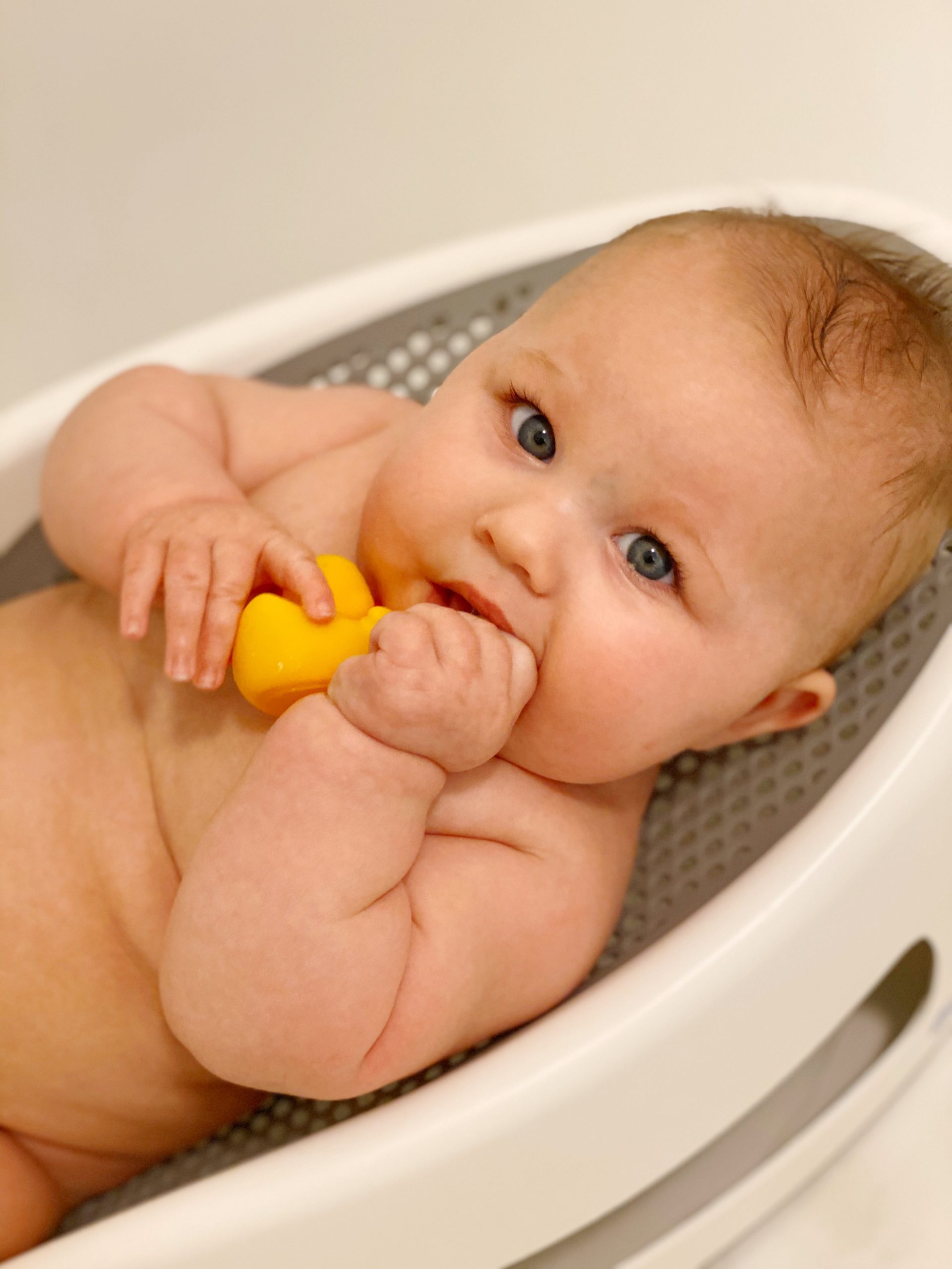 baby in bath with small rubber duckie